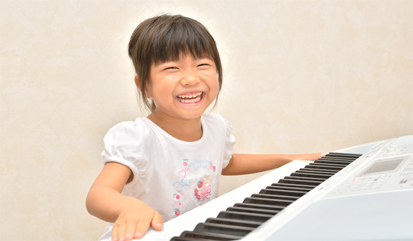 Child Smiling At A Piano Image